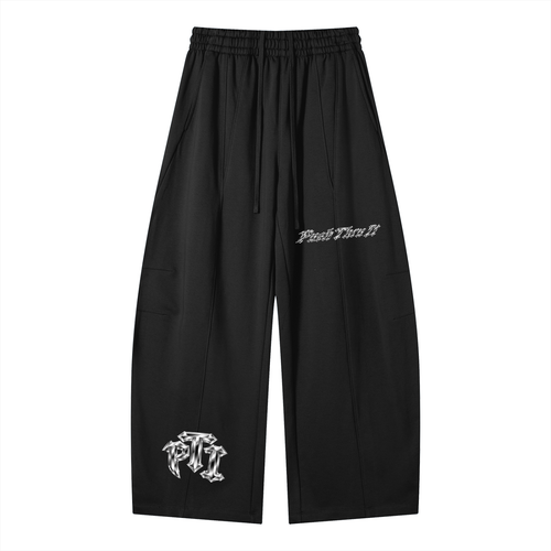 Black wide-leg sweatpants with an elastic waistband and drawstring, featuring white gothic-style embroidered graphics on the left leg and right thigh, displayed on a solid white background.